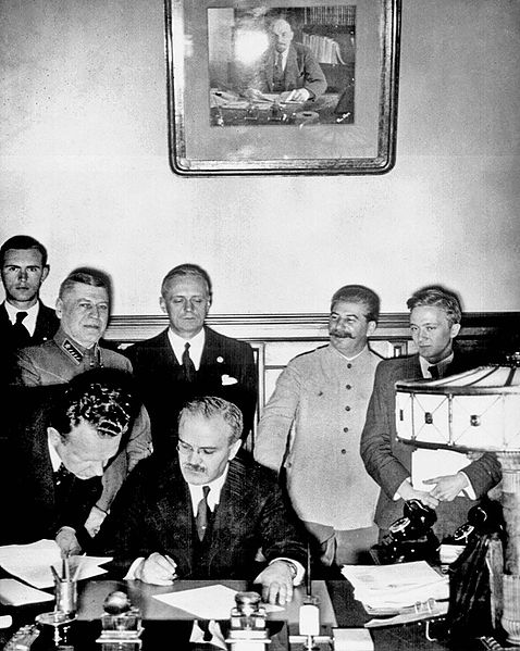 Молотов подписывает договор, за ним Риббентроп, справа Сталин